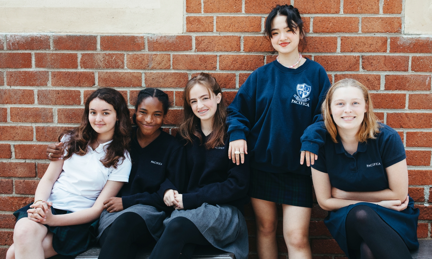 international students in front of brick wall