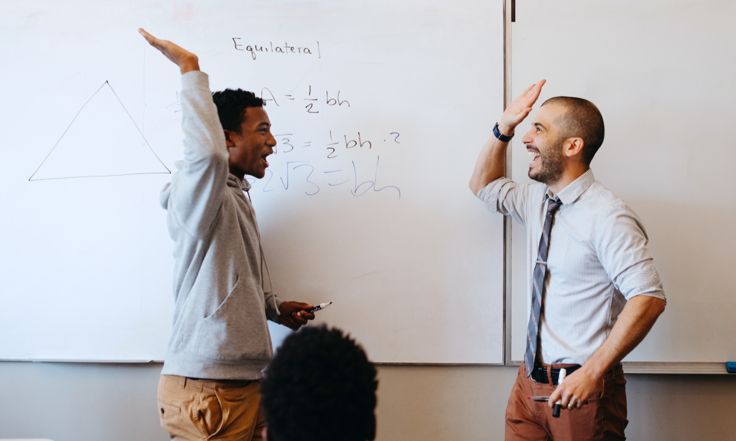 student and teacher high-fiving